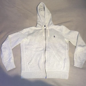 Polo Ralph Lauren Zip Hoodie - Säljer nu min gråa Polo Ralph Lauren Zip Hoodie i storlek S. Den är i utmärkt skick utan några fläckar alls. Tveka inte på att skicka ett meddelande vid funderingar eller om du vill ha flera bilder. Mvh