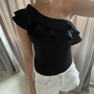 Svart volang topp - Super fin svart volang bodysuit. Den är storlek S och säljer så den är lite för stor i midjan och inte kommer till användning. 💗 Kom gärna med pris förslag, köparen står för frakten 💗🥰