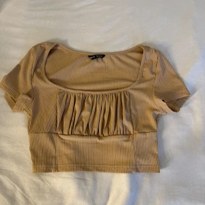 Sommar topp - En kort beige sommar topp i storlek S