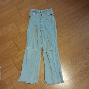 Bootcut hål jeans  - Bootcut jeans med hål i knäna. Bra skick. En liten orange fläck som inte syns lika stor som 2 saltkorn. Köpt för 279 kr säljer för 130 kr. Säljer pga att dem inte e min stil