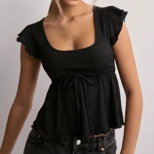 Svart topp - Säljer den här svarta toppen från Nelly som aldrig använts. Bilden är från Nellys hemsida 