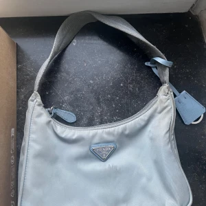 Prada nylon väska  - Flertal fläckar men den är lätt att tvätta pga nylon materialet. Box och dustbag inkluderat men inget äkthetsbevis