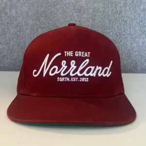 En vinröd Norrlands keps köpt från HatStore🧢Den är utmärkt bra skick & sparsamt använd förutom en blekning längst in på undersidan av skärmen. Men det syns ju inte när man har på sig den🙌🏼Bara använd en sommar & sen dess har den bara legat. Nypris 399