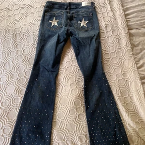 Lågmidjade bootcutjeans med glitterstenar - Det är jag själv som lagt till detaljerna på jeansen.