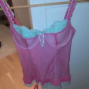 Rosa och turkos korsetttop! - Säljer denna jätte söta och snygga festoppen/ korsetten verkligen summer vajb💗🌸 den är labeld L men pasar nog S/M bäst jag är S/M. Se sista bilden för spännet, ajusterbara band även😽C kupa skulle jag tro! (Laddar upp igen pga dåligt intresse)