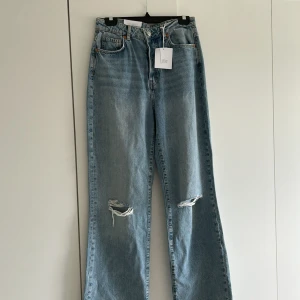 Oanvända Jeans Från Bikbok - Säljer dessa jeans som jag aldrig ens användt pga kunde inte lämna tillbaka och de passar inte mig. Raka långa ljusblåa jeans med slitning på knäna. Storlek W31L32. Nypris 699 🌸