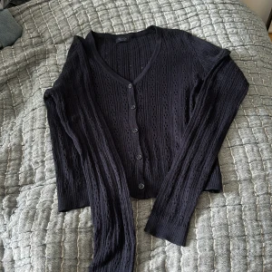 Stickad tröja - Mörkblå stickad tröja med knappar där fram. Den är lite croppad men med långa ärmar. Köpt från Brandy Melville.