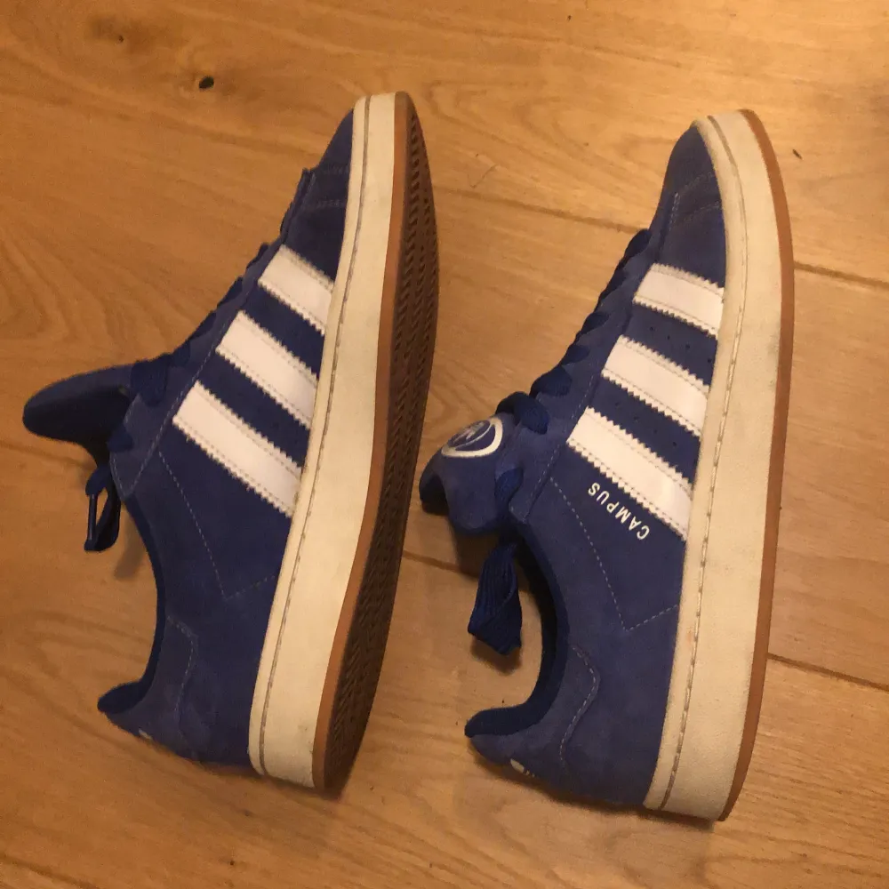 Säljer dessa Adidas Campus 00S haft dom i en månad ungefär men sparsamt använda. Skick:8/10 lite sol blekta men inget man tänker på när man har på sig dom. Man får med vita och blåa snören. De skickas i original box. Köparen står för frakten.😀. Skor.