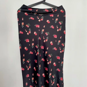 Blommig kjol i satin i storlek XS - Jättefin blommig kjol på svart bas i satin med fint fall. Gillar den mycket men kommer tyvärr inte till användning. Mycket bra skick, inga skavanker. Passar XS-S 🌸