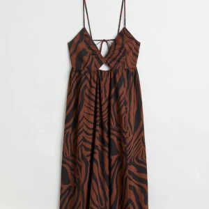 Klänning  - V-ringad klänning med cut-out vid magen och öppen rygg. Endast använd 1 gång.