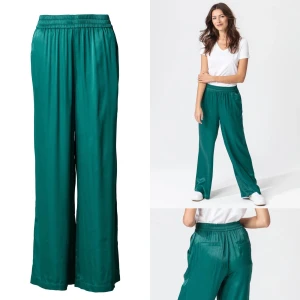 Fina glansiga vida byxor i viskos  - Otroligt bekväma och sköna byxor i glansig viskos (sidenkänsla) resår i midjan, fickor i sidorna och bakfickor. Stora. Tycker färgen är mörk turkos/petrol. Sparsamt använda i fint skick, dock några små tråddragningar vid granskning, se närbilder.