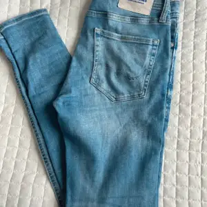 Ett par ljusa jeans med slitningar från jack&jones , i använt skick men inga fel på de. Stl: 30x32