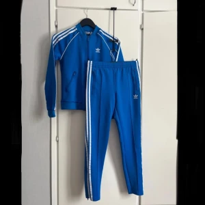 Adidas set - Mycket bra skick  Byxorna är tight i modellen Tröjan är lite seg i dragkedjan men inget som påverkar plagget Byxa uk 6 Tröja uk 4