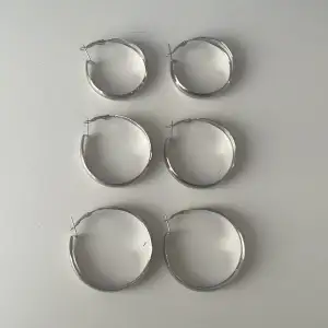 Silverfärgade örhängen ringar / hoops. Obs ej äkta silver! Säljer ett par för 25kr, alla tre för 60kr. Frakt kostar 18kr (ett frimärke). 