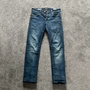 Säljer nu dessa as feta Jack and Jones jeans. Model: Slim Glenn, Storlek: 27 32. Nypris på dessa är 500-600kr, mitt pris är endast 249kr! Slitningarna är gjorda själv. Hör av er vid minsta fundering.  