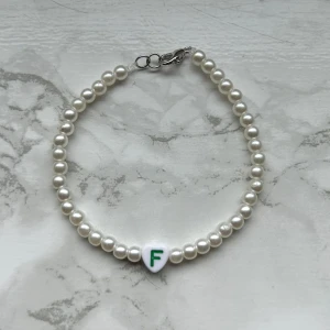 Pärlarmband ”F” - Handgjort pärlarmband med bokstaven ”F” 💚 35 kronor!  Silver detaljer, köp via köp nu eller kom privat för 18 kronors frakt! (Frimärke)