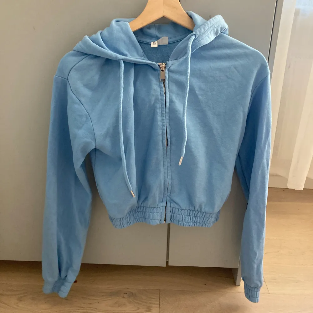 En blå croppad hoodie med dragkedja från HM divided i storlek xxs. Använd men i bra skick😊. Hoodies.