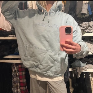 Blå hoodie - Säljer nu min ljusblå hoodie då den inte kommer till användning! Finns lite skavanker som visas på en av bilderna. Storlek L men skulle säga s/m