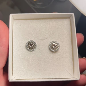 Lily and rose örhängen - Supersöta lily and rose örhängen jag inte fått använding för! De är sparsamt använda och ser ut som nya. Stenarna i mitten är ljusrosa vilket inte syns så tydligt på bilderna. 