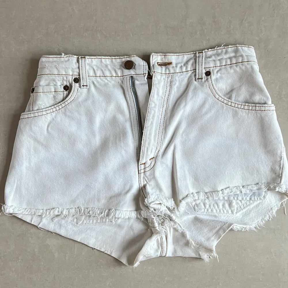 Vita vintage levis shorts. Märket där bak är halvt av - men så var de redan när jag köpte dem. Säljer då jag vuxit ur dem. Sitter baggy på en XS skulle jag säga. Lappen är sliten så ser inte storlek (se sista bilden). . Shorts.