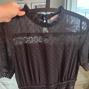 Jätte fin klänning med fina detaljer - Fin klänning med fina detaljer. Färg svart grå. Korta ärmar, lång inte hela vägen ner till golvet dock. Jag är 163 cm.  Köpt utomlands. 