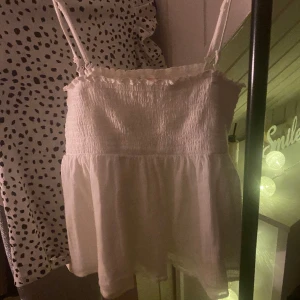 Vit volang topp  - En söt vit topp med volang. Banden är justerbara men går även att ta av. Priset går att diskutera