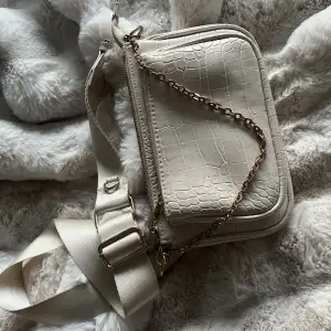 En fin cremevit handväska med ett justerbart axelband🤍Den har två fack samt en liten guld kedja som är en extra detalj. Använd ett par gånger men fortfarande fin.