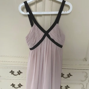 Beige klänning med svarta pärlor - Supersöt beige klänning med svarta pärlor på svarta bandet. Från HM strlk 36. Är knälång (bilden kapas kortare men skriv för fler bilder). Ej använd utan hängt i garderob flera år. 