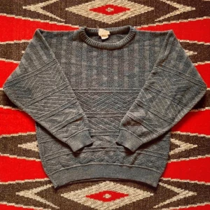 90-tal, Stickad Tröja - RESERVERAD Dundersnygg stickad 90-tals tröja i grå ull-akryl-mix. Fin att ha över en snygg skjorta! Använd men i mycket fint skick, inga synliga defekter. Längd-60 Axlar-56 Bröst-56 Ärm-50 Kant-40 (cm). 30% Ull 70% Akryl. 