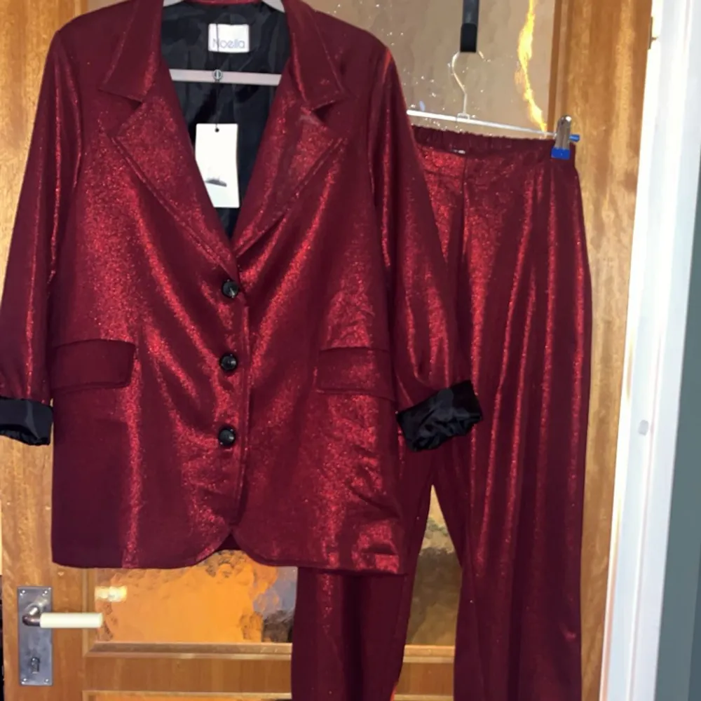 Coolast på festen?  Ja lätt i denna kostym i glittrigt rött tyg i small från Noella  Nypris ca 3000:-. Kostymer.
