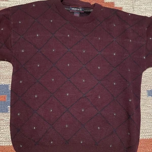 Stickad vinröd tröja  - Stickad vinröd tröja med mönster köpt second-hand. Helt okej passform på mig som är 178