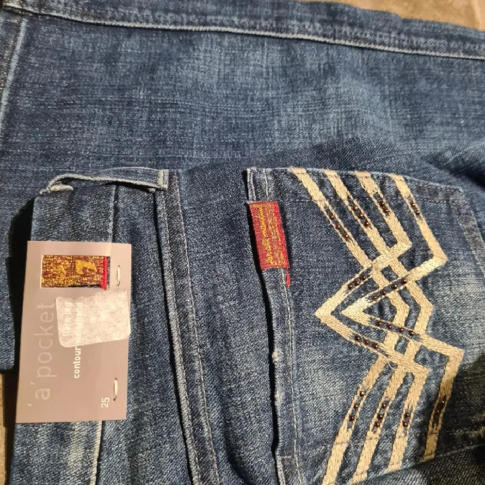 Helt nya,  grymt snygga 7 For All Mankind flare lowrise jeans. Aldrig använda, med lapp kvar. Storlek XS. Midja 33 CM (*2)( W25). Innerbenslängd 77 CM. Kom gärna med bud OM DU HAR TÄNKT FULLFÖLJA KÖPET.. Jeans & Byxor.