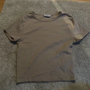 Beige t-shirt  - T-shirten är i fint skick knappt använd är köpt på Gina tricot och den är lite cropped i modellen