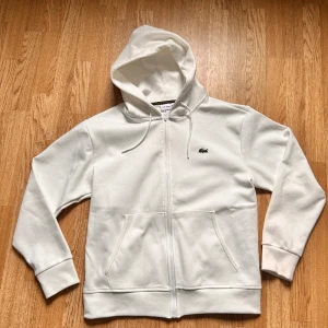 Lacoste zip hoddie  - Lacoste zip up hoddie nyskick aldrig använt med tagg. Strlk M och sitter som M