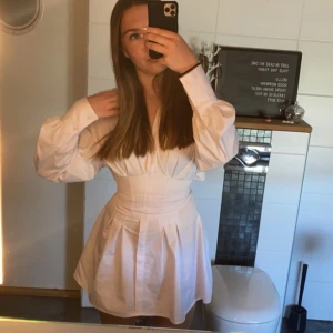 Vit skjortklänning - Jättesöt skjortklänning köpt från Zalando! Har korsett i midjan som går att justera med knyt, perfekt till sommaren/skolavslutning! Storlek S, fint skick!💓