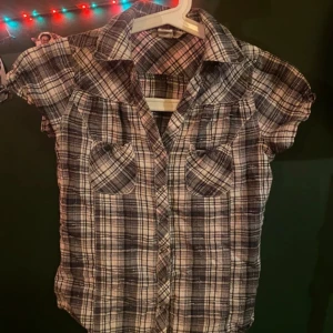 Skjorta  - Rutig skjorta i rosa, svart och vitt.  Sitter supersnyggt, men är i mindre passform.  Köparen står för frakt. 