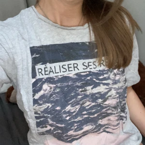 Grå T-shirt  - Grå T-shirt med tryck fram, lite oversiced på mig som brukar ha M! 