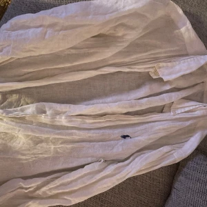 Linne skjorta Ralph Lauren vit - Jättesnygg linneskjorta från Ralph Lauren. Tyvärr för liten. Strl M OBS det är ett litet hål under bådarna armarna, går enkelt att laga hos en skräddare för en hundralapp men eftersom den är för liten för mig har jag inte orkat det därav lågt pris
