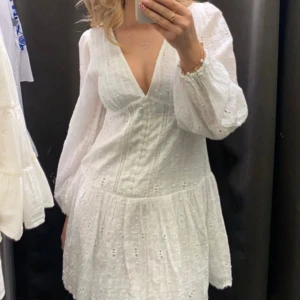 Studentklänning - Säljer den här vita klänningen med spetsdetaljer från Zara som är perfekt till studenten. Klänningen har inte använts och är i storlek M💕