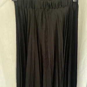 Lång kjol  - Lång kjol från Gina trixig i plisserat material med resår upptill. Den är lite liten i storleken så sitter mer som S än M. Inga defekter! 