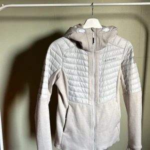 Tunn jacka - Beige jacka från Didriksons i storlek 36. Smått missfärgad insidan av kragen, se bild 2. Figurnära vilket ger en väldigt fin passform.