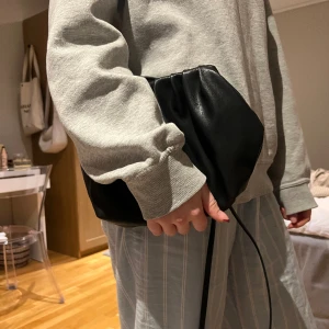 Svart väska  - Säljer denna snygga väskan som funkar lika bra som en clutch (du kan ta av banden) 