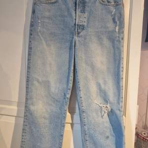 Ett par raka ljusblå jeans från hm med hål på knät. De har en lite gräsfläck på ena benet den kanse går att tvätta bort. Har bara använt dem ett fåtal gånger 