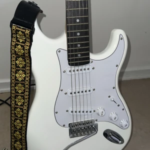 Elgittarr med inkluderat gitarrband, ställ och högtalare. - En sprillans ny elgitarr som är helt oanvänd och i nytt skick. I priset inkluderas ett helt nytt gitarrband, ställ och högtalare som hör till gitarren. Vid intresse kan priset diskuteras!