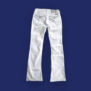 Vita lågmidjade flare/bootcut jeans med diamanter/rhinestones och flap pockets. Storlek W27 passar st 34 EU. Midja 39 cm, innerben 84cm. Fråga gärna om fler bilder 💕