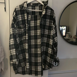 Rutig skjorta  - Overvized Svartvit rutig skjorta jättesnygg över bikini eller till finare tillfällen funkar också som klänning då den går ner till knävecken bak och mitten på låren fram 