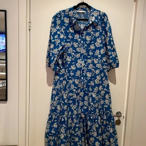 Klänning med en volang nedtill och puffärm från Zara - Använd en gång och är som ny. Den har ett härligt luftigt material och är normal i storlek.