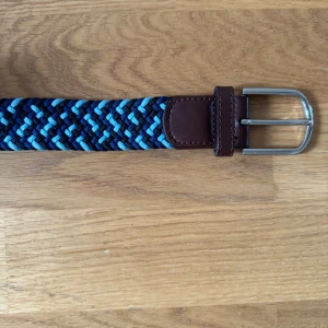 Bälte John Henric - Säljer ett blått flätat bälte från John Henric. Använd mycket sparsamt. Bältet är 100 cm och passar de flesta eftersom den inte har några bestämda hål. Nypris : 499