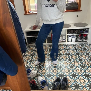 Coola, unika jeans - Jättecoola bootcut jeans i superbra skick med blomdetaljer.💗 Liten i storlek (passar mig som har storlek 36)