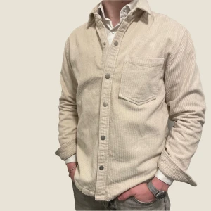 Manchester overshirt  - Snygg beige overshirt från märket ”reserved”. Plagget är i storlek S men passar även M. Fint men använt skick. Modellen är 182cm lång. Fråga gärna vid funderingar. 